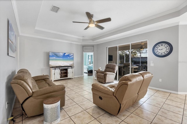 tiled living room featuring a raised ceiling, ceiling fan, and ornamental molding