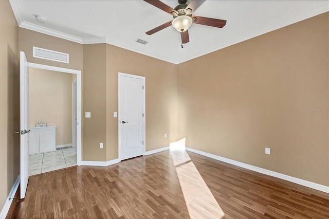 unfurnished bedroom featuring ceiling fan, crown molding, and wood-type flooring