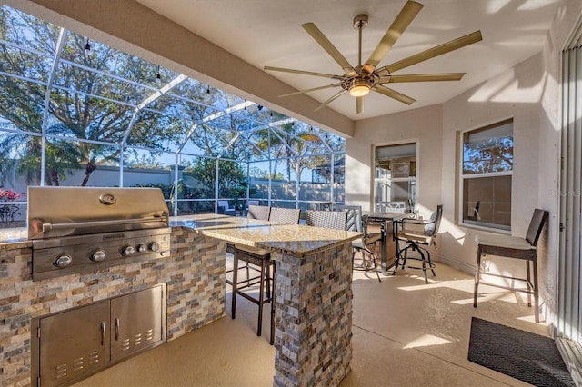 view of patio featuring exterior kitchen, area for grilling, a lanai, and a bar