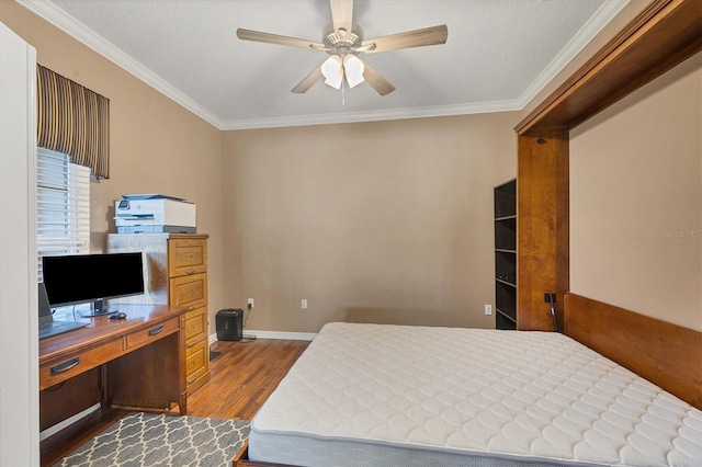 bedroom featuring a ceiling fan, crown molding, baseboards, and wood finished floors