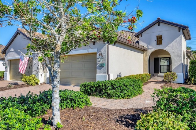 11265 Mc Dermott Ct, Englewood, FL 34223 - view of front of property featuring a tile roof, a garage, stucco siding, and driveway