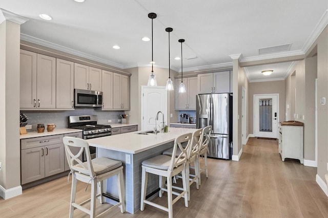11265 Mc Dermott Ct, Englewood, FL 34223 - kitchen with appliances with stainless steel finishes, gray cabinetry, a breakfast bar area, tasteful backsplash, and light wood-style flooring