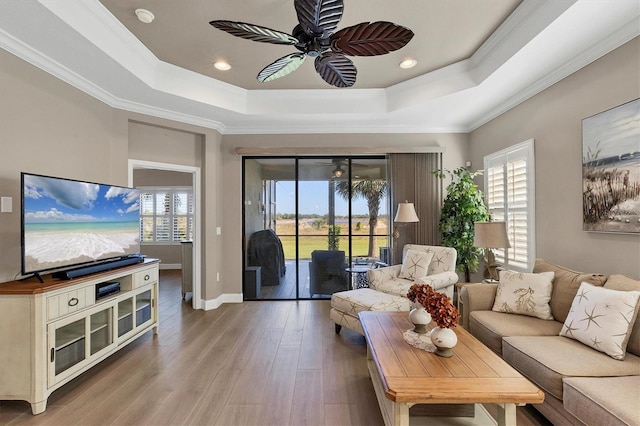 11265 Mc Dermott Ct, Englewood, FL 34223 - living area featuring a tray ceiling, a ceiling fan, wood finished floors, recessed lighting, and ornamental molding
