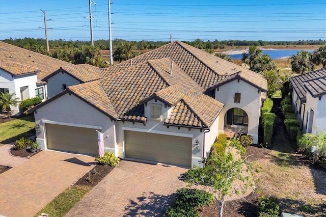 11265 Mc Dermott Ct, Englewood, FL 34223 - mediterranean / spanish home featuring a tile roof, a garage, stucco siding, and decorative driveway