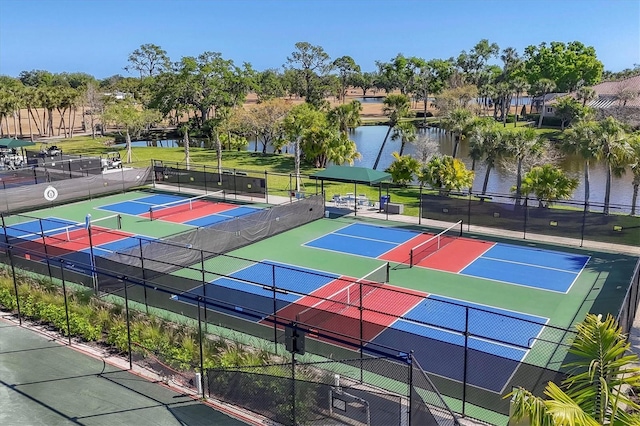 view of tennis court featuring a water view