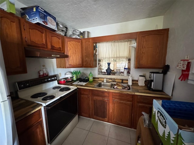 kitchen featuring light tile patterned flooring, sink, white appliances, and a textured ceiling