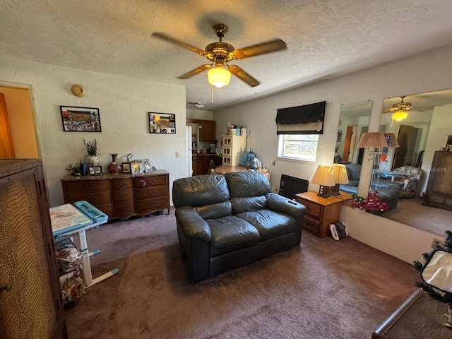 carpeted living room with ceiling fan and a textured ceiling