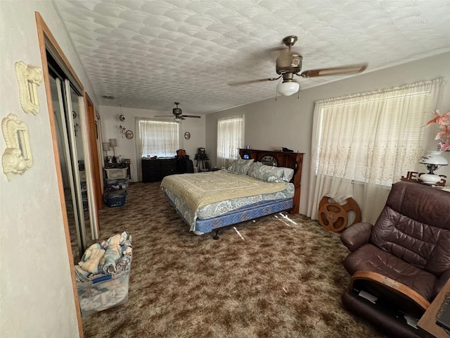 carpeted bedroom with ceiling fan, a textured ceiling, and a closet