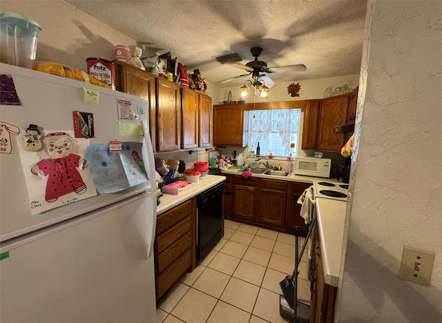 kitchen with white appliances, sink, ceiling fan, light tile patterned floors, and a textured ceiling