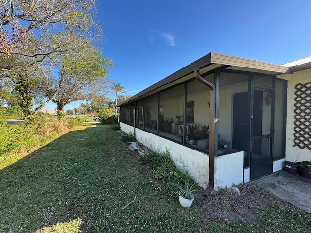 view of side of property with a sunroom and a yard