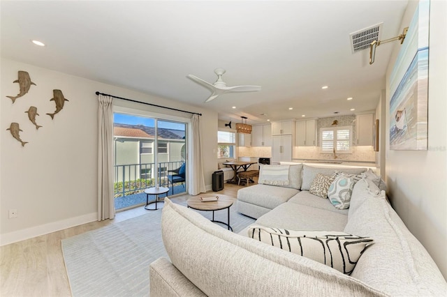 living room with ceiling fan and light hardwood / wood-style floors