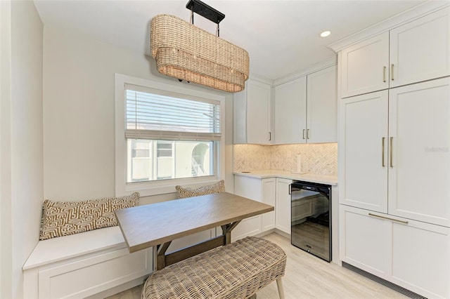 dining area featuring breakfast area, wine cooler, and light hardwood / wood-style flooring