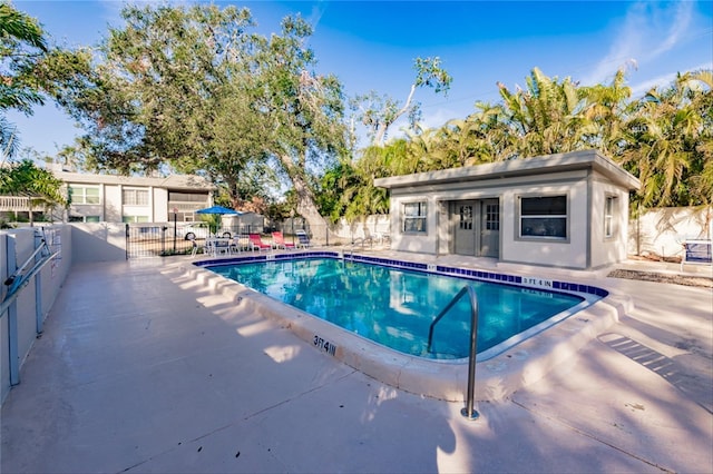 view of pool featuring a patio area and an outbuilding