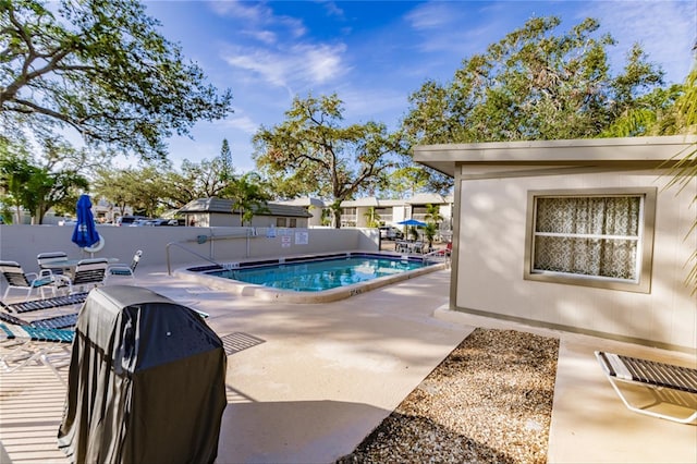 view of swimming pool featuring a grill and a patio