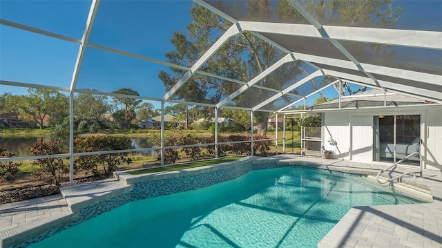 view of pool with a water view, glass enclosure, and a patio area