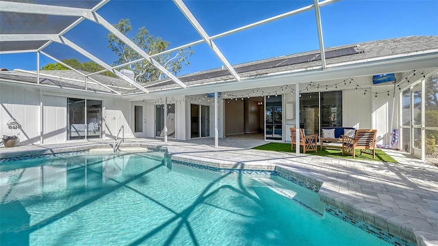 view of pool with glass enclosure and a patio area