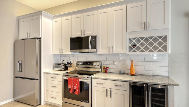 kitchen with wine cooler, backsplash, white cabinets, light stone countertops, and stainless steel appliances