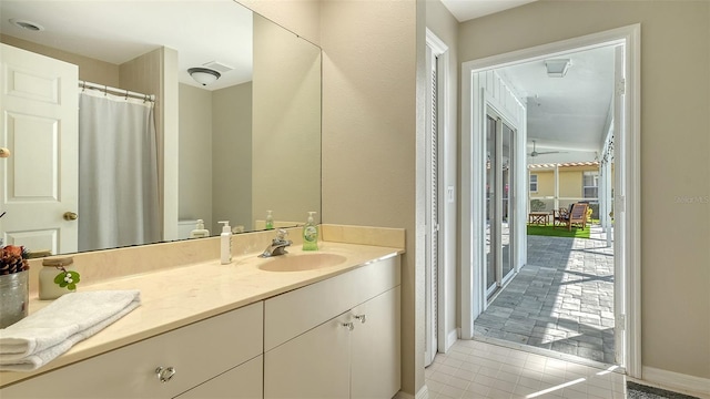 bathroom with toilet, tile patterned flooring, and vanity