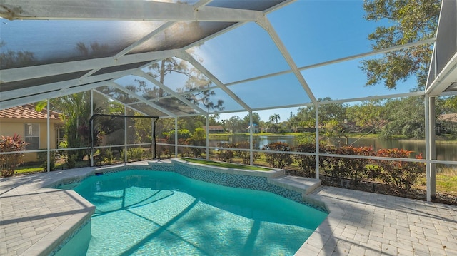 view of pool featuring glass enclosure, an in ground hot tub, a patio area, and a water view