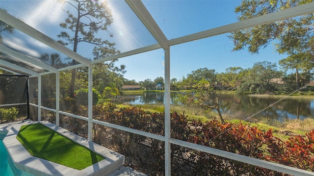 sunroom featuring a water view