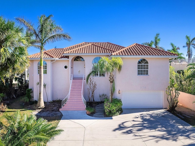 508 Siesta Dr, Sarasota, FL 34242 - mediterranean / spanish home featuring an attached garage, concrete driveway, a tiled roof, stucco siding, and stairs
