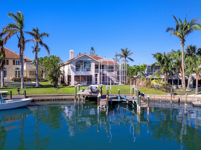 508 Siesta Dr, Sarasota, FL 34242 - back of property featuring boat lift, a water view, a yard, a chimney, and stucco siding