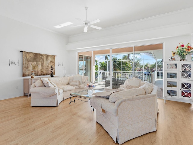 living room with ceiling fan, ornamental molding, and light wood-type flooring