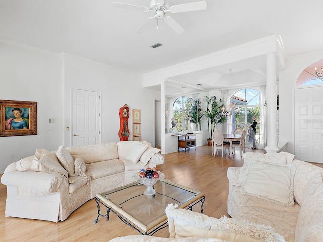 living room with hardwood / wood-style floors, ceiling fan with notable chandelier, decorative columns, and ornamental molding