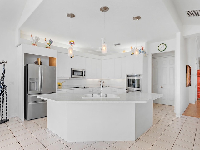 kitchen with stainless steel appliances, sink, a center island with sink, white cabinetry, and hanging light fixtures