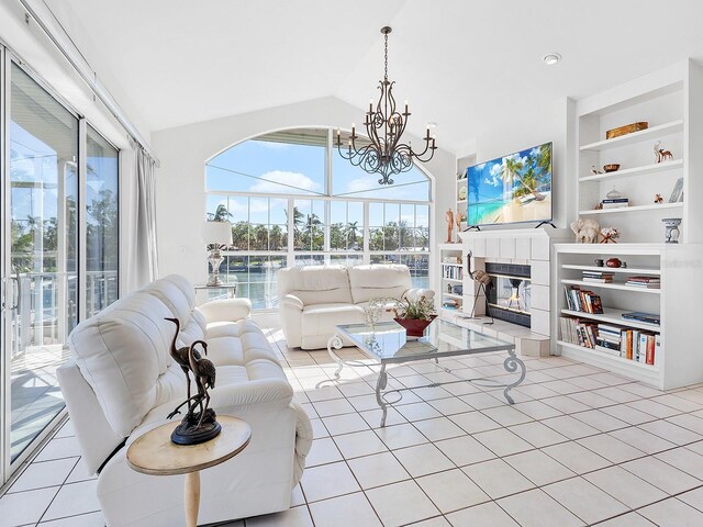 508 Siesta Dr, Sarasota, FL 34242 - living area with a chandelier, a tiled fireplace, built in features, light tile patterned flooring, and high vaulted ceiling