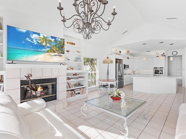 tiled living room with a tile fireplace, built in shelves, high vaulted ceiling, and ceiling fan