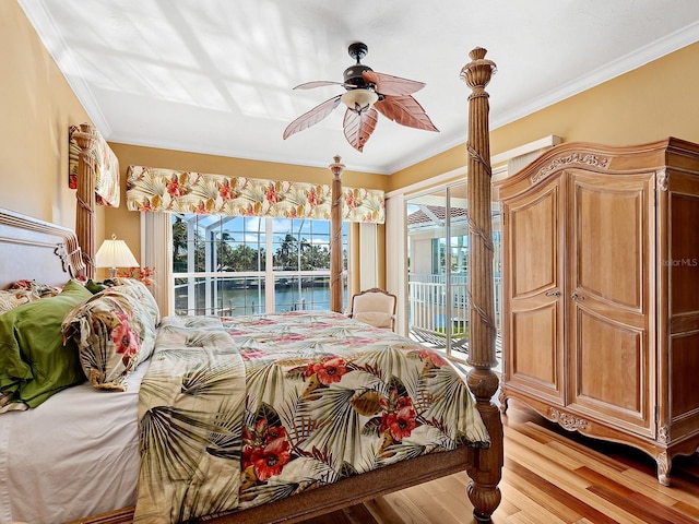 bedroom featuring a water view, ceiling fan, access to exterior, light wood-type flooring, and ornamental molding