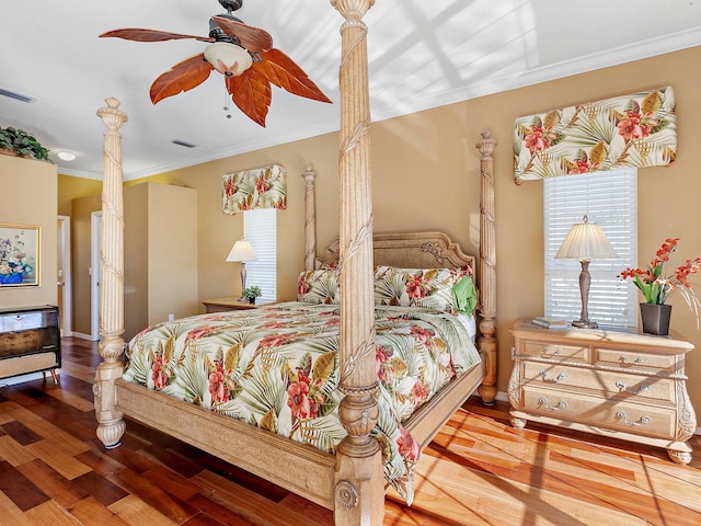 bedroom with hardwood / wood-style floors, ceiling fan, and crown molding