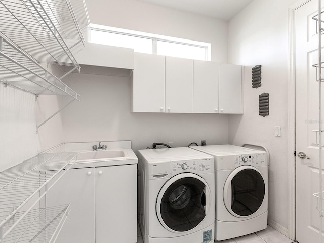 laundry area with sink, light tile patterned flooring, cabinets, and independent washer and dryer