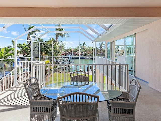 view of patio / terrace featuring a lanai and a water view