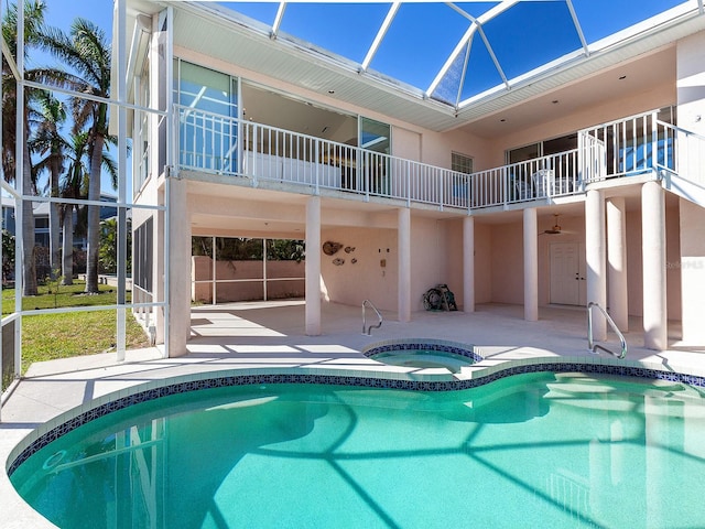 view of swimming pool with a lanai, an in ground hot tub, and a patio