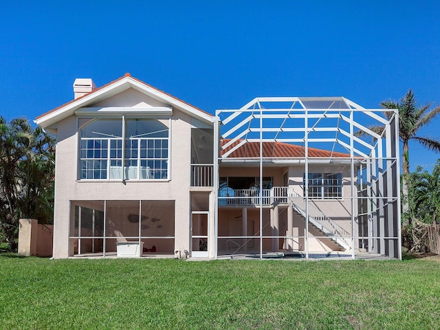 rear view of house featuring a lawn and a lanai