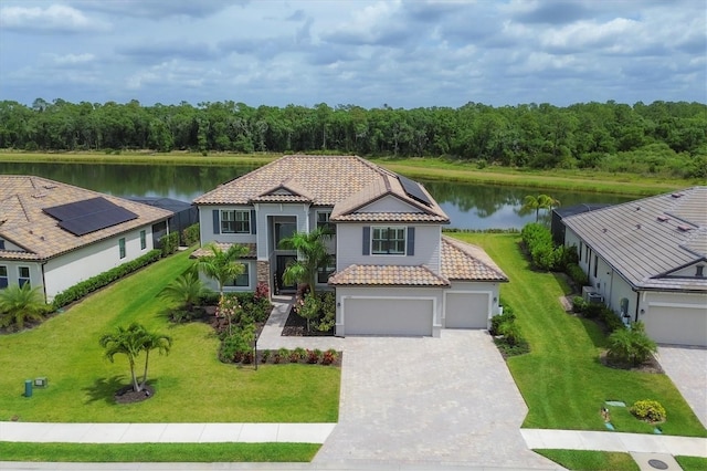 mediterranean / spanish-style house with a garage, a water view, and a front yard