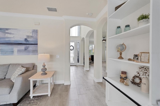 entryway with crown molding and light hardwood / wood-style floors