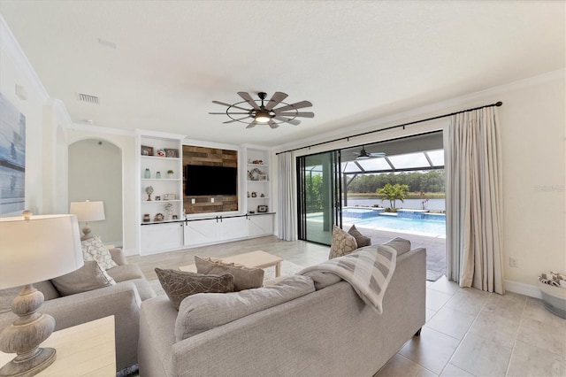 tiled living room with built in shelves, ceiling fan, and ornamental molding