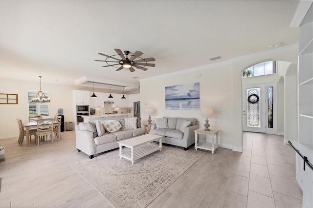 living room featuring ceiling fan with notable chandelier, light hardwood / wood-style flooring, and ornamental molding