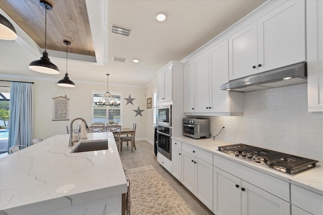 kitchen featuring pendant lighting, a healthy amount of sunlight, wood-type flooring, and stainless steel appliances