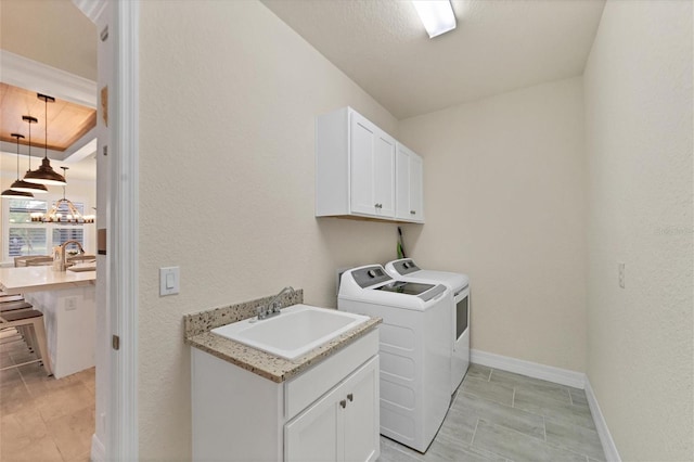 laundry room with washing machine and clothes dryer, sink, and cabinets