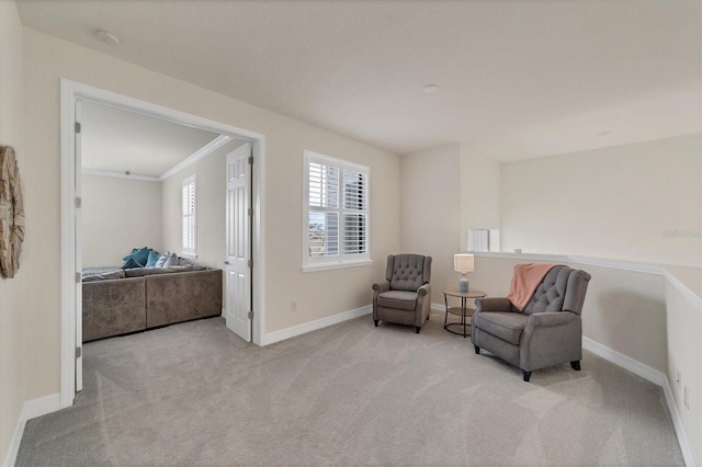 living area featuring light colored carpet and ornamental molding