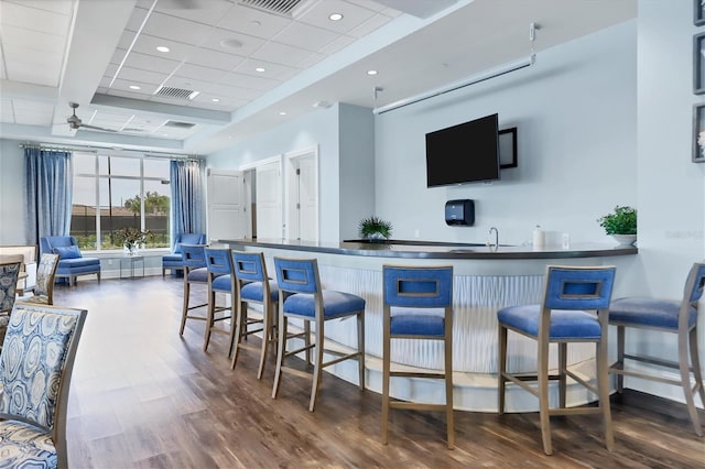 bar with dark hardwood / wood-style floors, ceiling fan, and sink