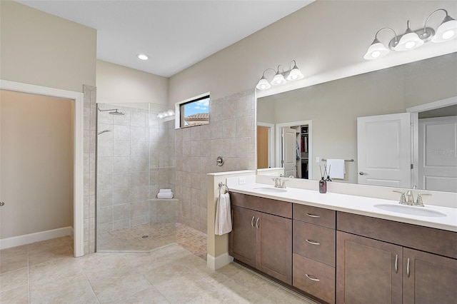 bathroom with tile patterned flooring, vanity, and tiled shower