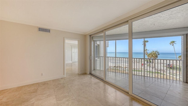 spare room with crown molding, a beach view, a water view, visible vents, and baseboards