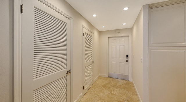 hallway featuring baseboards, light tile patterned flooring, and recessed lighting