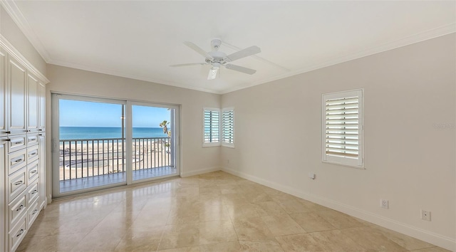 spare room with baseboards, a water view, a view of the beach, and crown molding