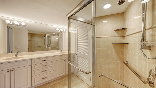 full bath featuring tile patterned floors, a sink, a shower stall, and double vanity